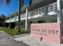 Charming two-story apartment building with unique lattice balcony design and lush palm surroundings at Palms on 31st.