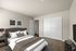 Elegant bedroom with a plush bed, stylish wall art, and spacious built-in closets, creating a cozy and inviting atmosphere.