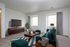 Inviting living room with modern decor, featuring a plush teal sofa, stylish coffee table, and a large flat-screen TV on a sleek wooden cabinet.