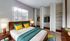 Bright and inviting bedroom with vibrant accents, featuring a cozy bed, ample closet space, and elegant decor.