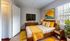Bright and inviting bedroom with chic yellow accents, modern furniture, and a large window for natural light.