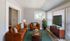 Inviting living room featuring a stylish brown leather sofa set, modern decor, and abundant natural light from large windows.