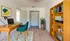 Cozy home office with stylish wooden desk, elegant chair, and vibrant bookshelf, ideal for productivity and inspiration.