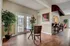 Charming dining area with elegant table setting, warm wood flooring, and natural light streaming through double French doors.