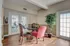 Elegant dining area with stylish furnishings and natural light, featuring a cozy round table, chic chairs, and indoor plants.