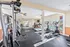 Bright and airy fitness center featuring state-of-the-art gym equipment with large windows for natural light and views of the outdoor pool.