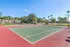 Vibrant tennis court nestled within lush greenery, perfect for active recreation and relaxation.