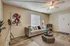 Chic living room with elegant decor, featuring a modern gray sofa adorned with plush cushions, stylish art, and natural light from a large window.