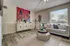 Modern living room with stylish decor, vibrant abstract wall art, and a cozy gray sofa accented by colorful cushions.
