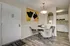Charming dining area with a modern design, featuring a round table, elegant chairs, and artistic wall decor, seamlessly connected to a sleek kitchen with stylish cabinetry.