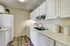 Charming kitchen with bright white cabinetry, cozy wooden flooring, and sleek modern appliances.