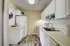 Charming kitchen with white cabinetry, modern appliances, and stylish wooden flooring, perfect for culinary enthusiasts.