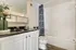 Elegant bathroom with a modern vanity, black countertop, and chic shower curtain.