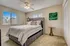 Bright and cozy bedroom with elegant decor, featuring a plush bed, stylish artwork, and ample natural light from large windows.