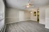Bright and airy living space with elegant wood flooring, modern ceiling fan, and chic pendant lighting.