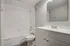 Modern bathroom with sleek white fixtures, a spacious tub, and elegant vanity, offering a clean and refreshing space.