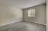 Bright, spacious bedroom with modern laminate flooring and a large window providing abundant natural light.