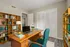 Inviting home office with stylish wooden desk, cozy teal chair, and well-organized bookshelves, perfect for productivity and focus.