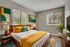 Bright and inviting bedroom featuring modern decor, vibrant yellow accents, and large windows with lush outdoor views.