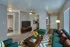 Inviting living room with modern teal sofa, bright accent pillows, and stylish coffee table with fresh flowers. Open layout leading to a fully-equipped kitchen and bathroom, highlighting comfort and elegance.