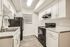 Modern kitchen with sleek black appliances and elegant white cabinetry.