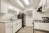 Bright and modern kitchen featuring sleek white cabinetry, elegant countertops, and stainless steel fixtures creating a chic culinary space.