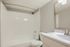 Contemporary bathroom featuring sleek fixtures, a pristine white bathtub, and a stylish vanity with a modern mirror.