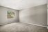 Bright and spacious room with plush carpet and a large window offering serene garden views.