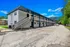 Charming two-story apartment complex with modern exterior and ample parking, surrounded by lush greenery.