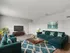 Inviting living room with plush teal sofas, stylish decor, and natural light for a cozy ambiance.