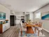 Modern dining area with stylish wooden table, elegant chairs, and a sleek kitchen backdrop, perfect for family gatherings.