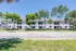 Inviting two-story apartment complex surrounded by lush greenery and shaded by mature trees, offering a serene and welcoming atmosphere.