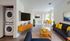 Modern living room with stylish mid-century furniture, bright yellow accents, and a convenient in-unit washer dryer. Open dining area with natural light.