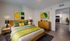 Elegant bedroom with modern wooden furniture, vibrant green and yellow decor, and a cozy ambiance. Accessible hallway leading to a sleek, contemporary kitchen.