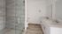 Elegant modern bathroom featuring a sleek glass shower and a double sink with polished countertops.