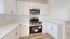 Bright modern kitchen with sleek stainless steel appliances, elegant white cabinetry, and polished countertops.