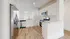 Bright, modern kitchen with sleek stainless steel appliances, stylish wooden flooring, and ample white cabinetry.