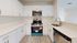 Sleek modern kitchen with stainless steel appliances, elegant white cabinetry, and polished countertops, offering a bright and inviting culinary space.