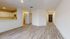 Modern open-concept apartment featuring sleek hardwood floors, elegant white cabinetry, and a stylish kitchen space.