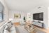 Bright and modern living room with sleek furniture, a large TV, and stylish decor in an inviting apartment.