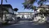 Charming apartment complex featuring elegant architecture and landscaped surroundings, with for rent signs visible at the entrance.