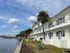 Charming waterfront apartment building with palm trees and scenic views, perfect for serene living.