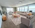 Bright and inviting living room with panoramic water views, featuring comfortable seating, elegant decor, and ample natural light.