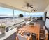 Spacious waterfront patio with elegant outdoor furniture, offering stunning views and relaxation under ceiling fans.
