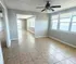 Bright and airy living space featuring large windows with stunning water views, tiled flooring, and a ceiling fan for comfort.