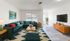 Bright and inviting living room with a chic teal sectional sofa, mid-century modern furniture, and elegant decor, perfect for relaxation and entertainment.