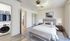 Elegant bedroom with plush king-size bed, modern decor, and a convenient walk-in laundry and closet area.