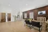 Bright and spacious living area with a modern open-concept design, featuring elegant hardwood floors and a stylish kitchen island with barstools.