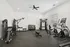 Modern home gym featuring top-of-the-line fitness equipment, including elliptical machines, a weight bench, and a full set of dumbbells, in a bright and welcoming space.