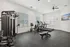 Modern fitness center with sleek exercise equipment, bright natural lighting, and a wall-mounted TV, perfect for energizing workouts.
